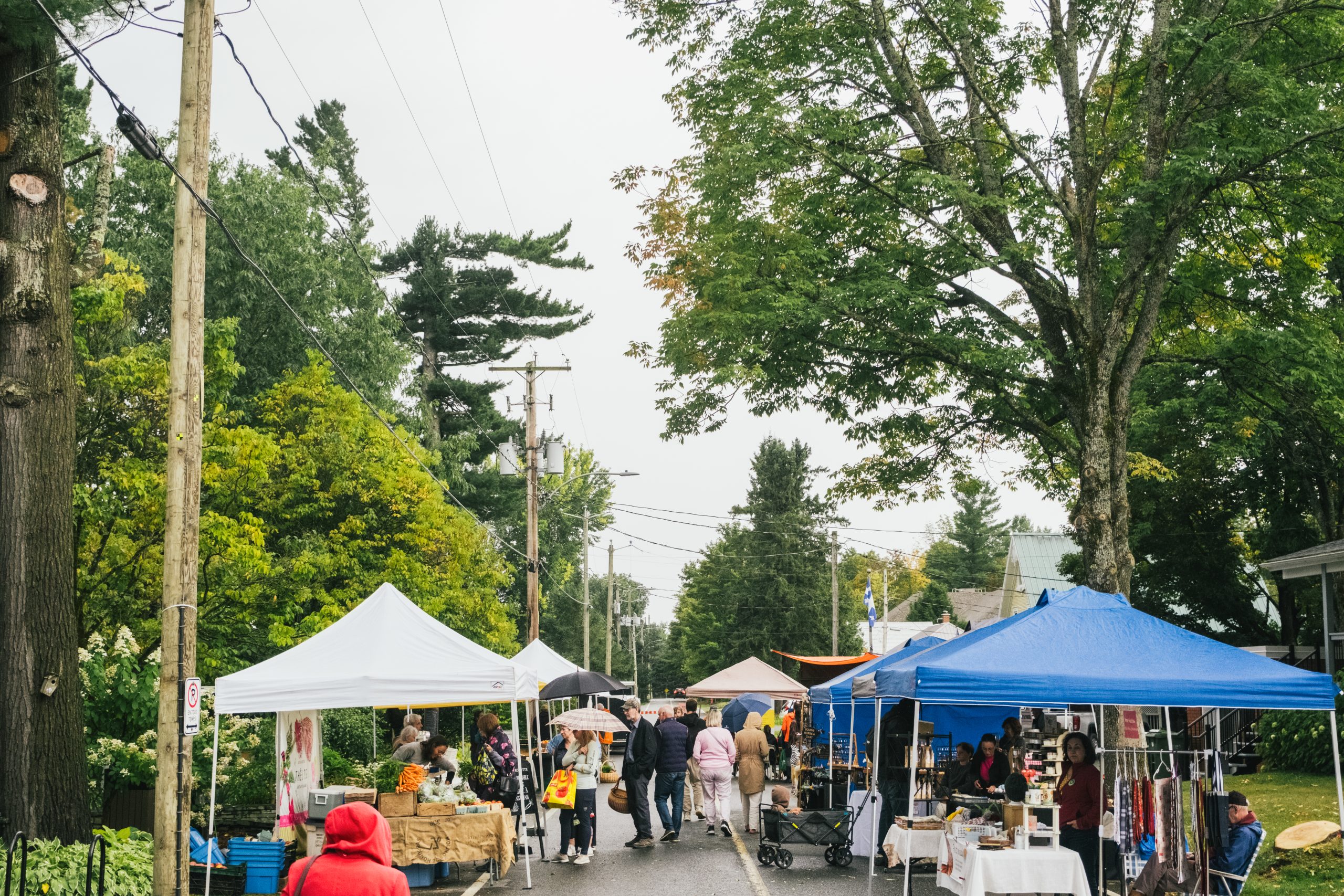 marché public extérieur en été, tente, exposants, visiteurs dans la rue