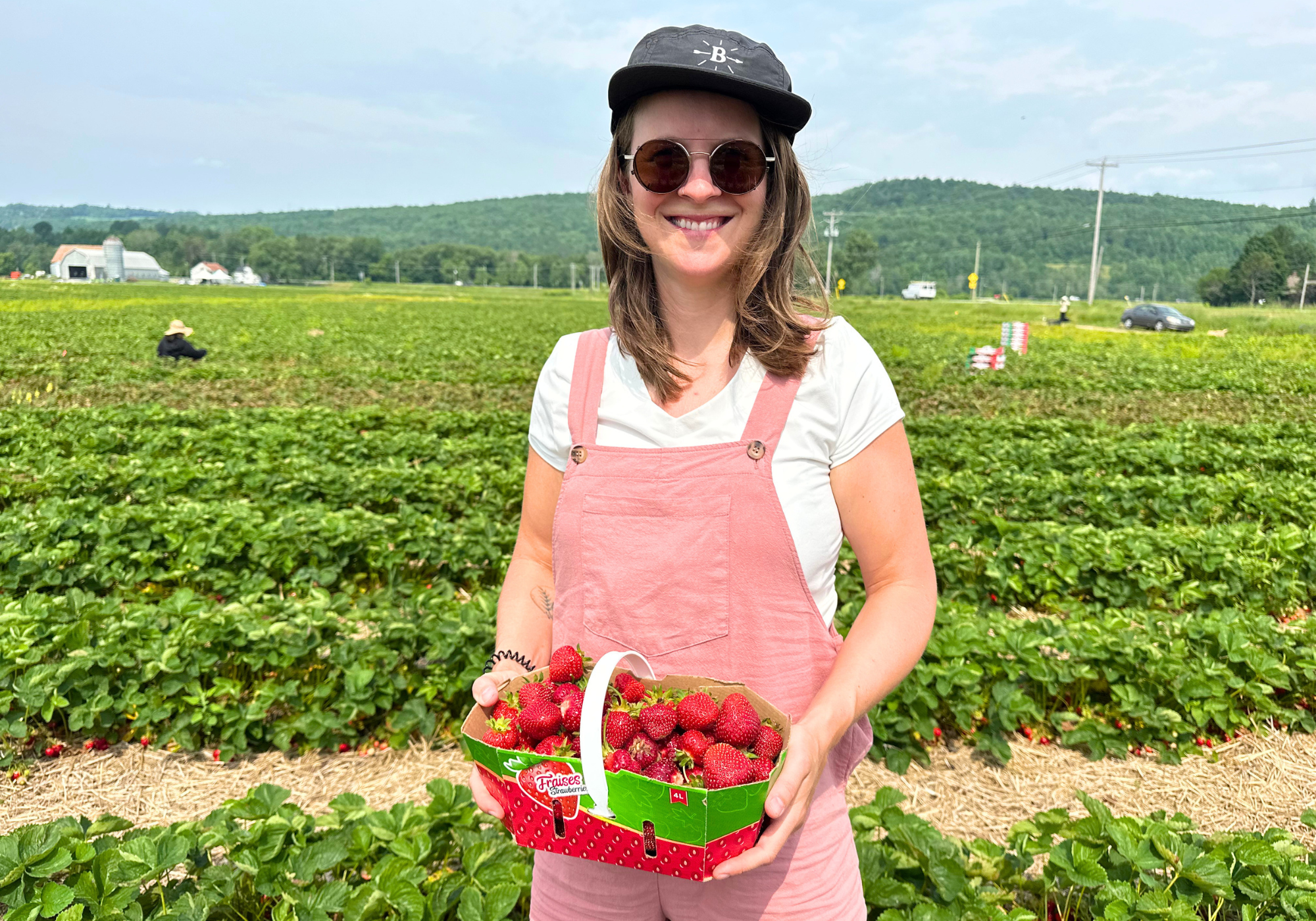 femme tenant panier de fraises qu'elle vient de cueillir dans les Cantons-de-l'Est autocueillette