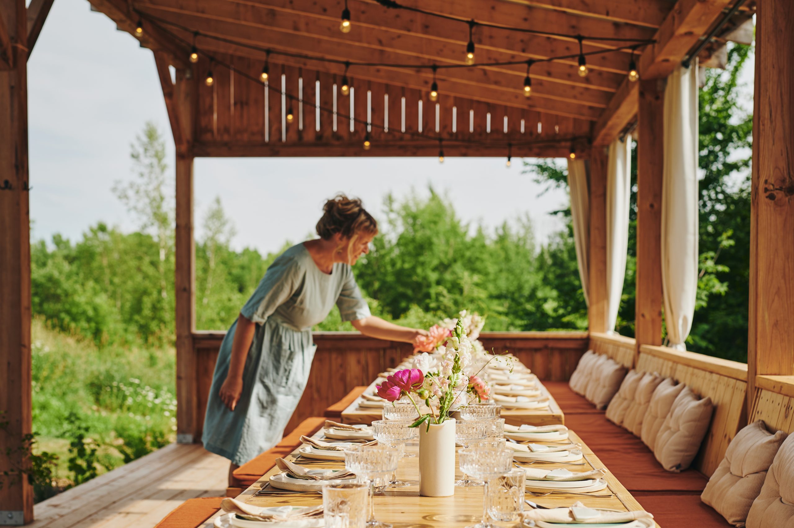 femme qui met la table sur une terrasse extérieure